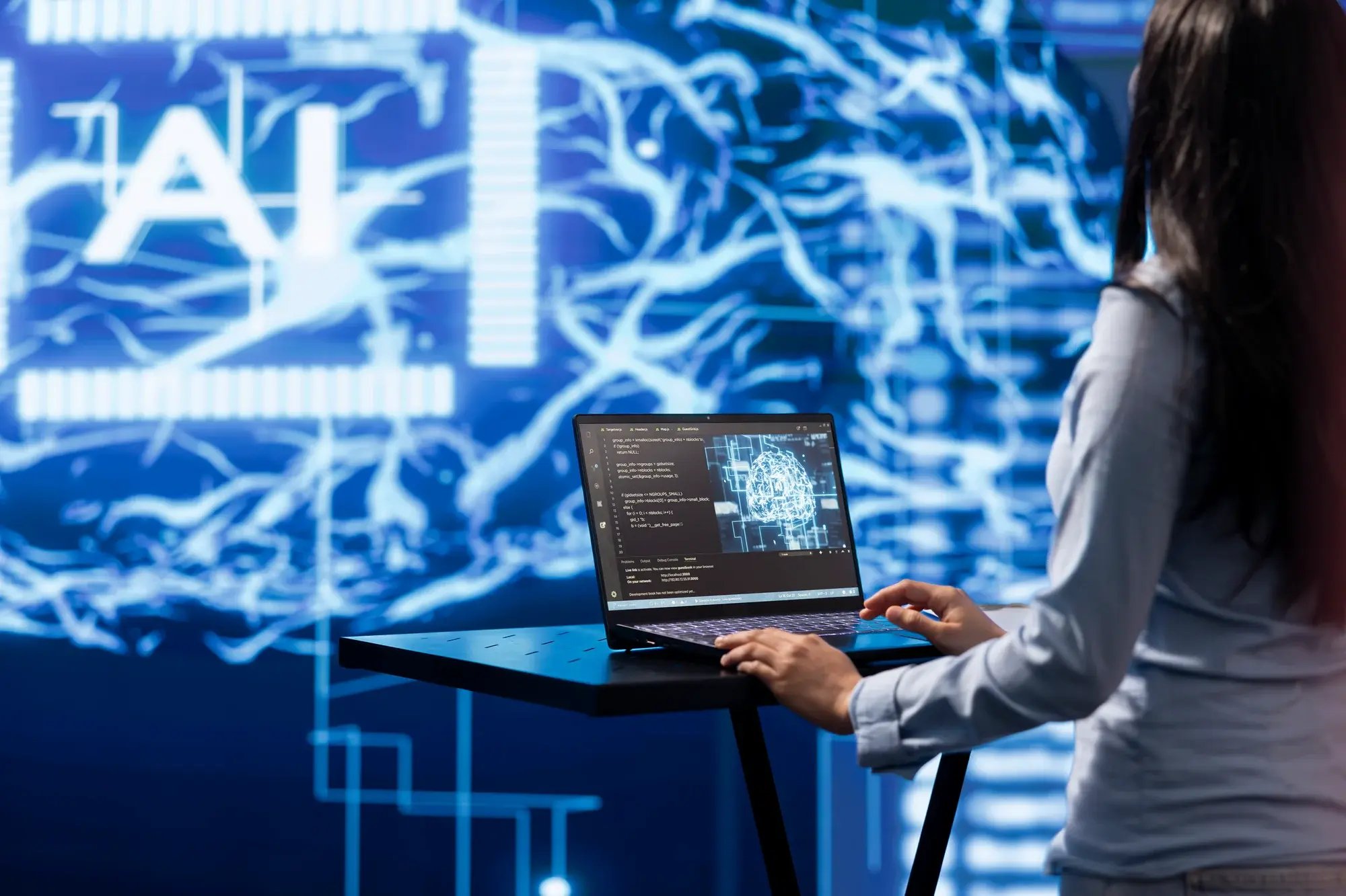 woman-using-laptop-in-front-of-ai-screen-2026-03-19-02-05-30-utc