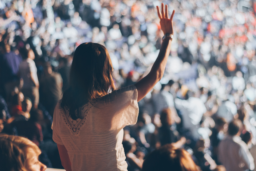 woman-raising-hand-at-festival