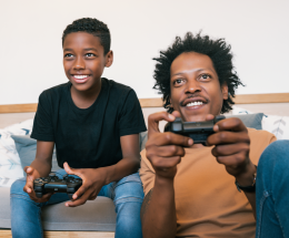 stock-photo-portrait-of-happy-african-american-father-and-son-sitting-in-sofa-couch-and-playing-console-video-1613310913